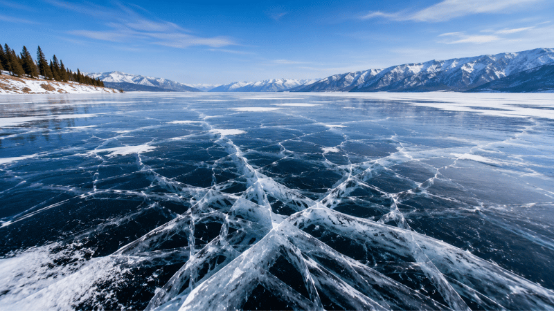 Frozen lake surface in winter showing ice floating on liquid water beneath, the property that allows aquatic life to survive cold winters due to why ice floats.